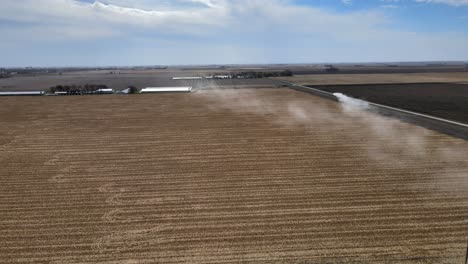 Luftdrohne-Nach-Aufnahme-Eines-Pickup-Trucks,-Der-Auf-Einer-Staubigen-Schotterstraße-Unter-Blauem-Himmel-Im-Ländlichen-Mittelwesten-Von-Iowa-Fährt