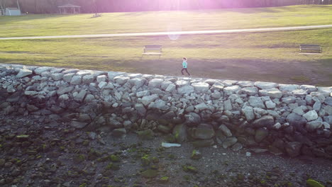 Excelente-Toma-Aérea-De-Una-Mujer-Corriendo-Por-Un-Parque-En-Rhode-Island