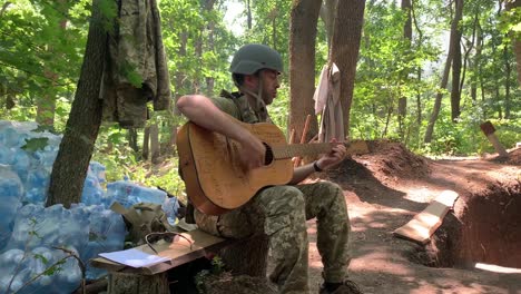 Un-Soldado-Ucraniano-Toca-La-Guitarra-En-Las-Trincheras-En-Primera-Línea-En-Donbas,-Ucrania