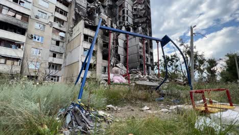 Un-Parque-Infantil-Con-Un-Oso-De-Peluche-En-Columpio-Y-Edificios-Son-Destruidos-Por-Ataques-Aéreos-Rusos-En-La-Región-Saltivka-De-Kharkiv-Ucrania