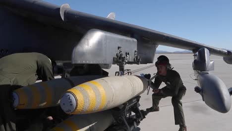 Los-Técnicos-De-Artillería-Del-Cuerpo-De-Marines-Estadounidenses-Cargan-Bombas-En-Un-Av-8b-Harrier-Ii,-Estación-Aérea-De-Yuma,-Arizona