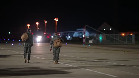 Los-Pilotos-De-Aviones-De-Combate-Del-Ala-48-Caminan-Por-Una-Pista-De-Aterrizaje-En-La-Noche,-Royal-Air-Force-Lakenhealth,-Inglaterra