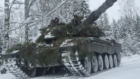 En-Cámara-Lenta,-Los-Tanques-Challenger-2-Del-Ejército-Británico-Conducen-A-Través-Del-Bosque-De-Estonia-Durante-El-Campamento-De-Invierno-De-Ejercicios-De-La-OTAN