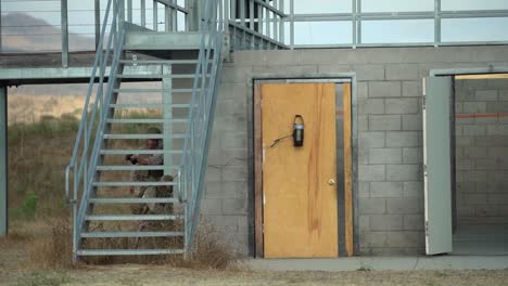 Ingenieros-De-Combate-Rompen-Una-Puerta-Usando-Pequeños-Explosivos-Antes-De-Entrar-En-Un-Edificio-De-Bloques-Durante-El-Entrenamiento,-Camp-Pendleton