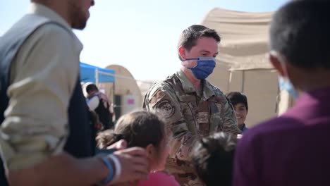 Us-Air-Force-Airmen-Play-Games-With-Afgani-Children,-Awaiting-Processing-After-Evacuation-From-Kabul-By-Biden-Administration,-Ramstein-Afb,-Germany