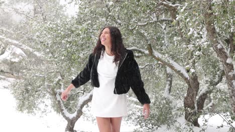 Una-Mujer-Joven-Con-Un-Vestido-Corto-Se-Deleita-Con-La-Nieve-Que-Cae-A-Su-Alrededor