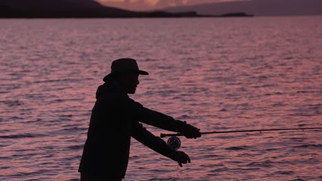 Ein-Fliegenfischer-In-Silhouette-Wirft-Seine-Rolle-Bei-Sonnenuntergang-In-Molokai,-Hawaii