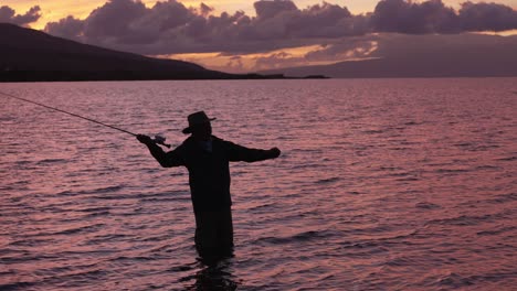 Se-Emplea-Cámara-Lenta-Para-Mostrar-Una-Toma-Completa-De-Pescador-Con-Mosca-En-Silueta-Al-Atardecer-En-Molokai,-Hawaii