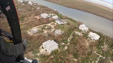 Helicóptero-De-La-Tripulación-De-La-Guardia-Costera-Estadounidense-Sobre-Los-Barrios-De-La-Isla-Dañados-Por-La-Tormenta-El-Huracán-Ian-Cerca-De-La-Playa-De-Fort-Myers,-Florida