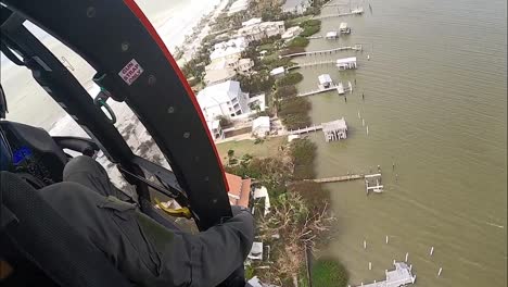 Helicóptero-De-La-Tripulación-De-La-Guardia-Costera-Estadounidense-Sobre-Los-Barrios-De-La-Isla-Dañados-Por-La-Tormenta-El-Huracán-Ian-Cerca-De-La-Playa-De-Fort-Myers,-Florida