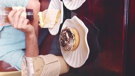 Vertical-video-of-a-man-drinking-iced-coffee-from-a-disposable-plastic-cup-in-a-cafe