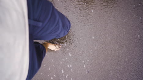 VERTICAL-feet-walking-POV-in-black-sand-tropical-beach-ocean-sea-waves