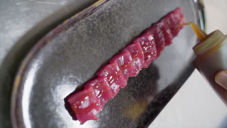 Chef-pouring-soy-sauce-on-bluefin-tuna-sashimi-during-its-preparation-in-slow-motion