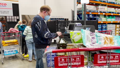 Man-with-mask-at-self-checkout-line-at-Costco