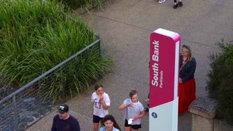 Friends-and-family-hanging-out-at-south-bank-parklands,-people-walking-and-strolling-on-riverside-promenade-at-the-recreational-precinct-at-Brisbane-city,-Queensland