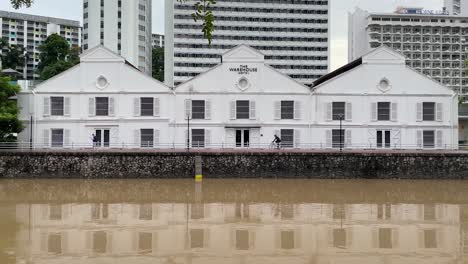 La-Gente-Va-En-Bicicleta-Y-Pasea-Por-El-Hotel-Almacén-Con-Vistas-Al-Río-Singapur-En-Robertson-Quay,-Singapur