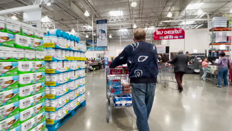 Caminando-Detrás-De-Un-Cliente-Masculino-Con-Carrito-De-Compras-En-La-Línea-De-Pago-De-Costco