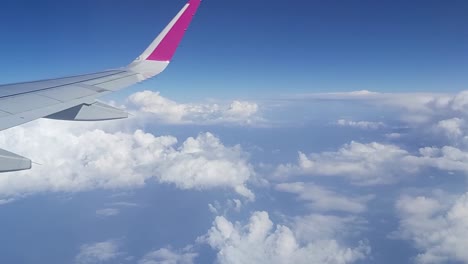 shot-looking-through-airplane-window-and-showing-the-sky-and-one-the-airplane's-wings