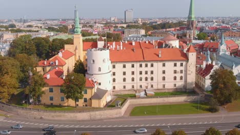 Atemberaubende-Luftdrohnenaufnahme-Des-Rigaer-Schlosses-Mit-Stadtbild,-Kreispfanne,-Tag