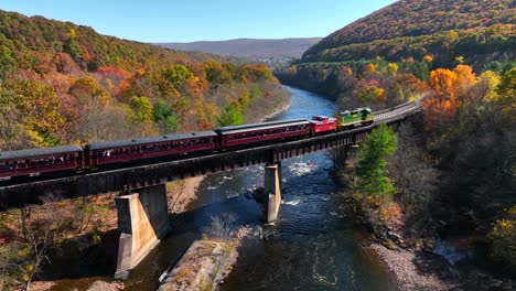 Lehigh-Gorge-Scenic-Railway-crosses-river-bridge-in-mountains-during-autumn