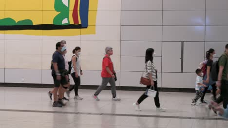 Large-crowds-of-Chinese-commuters-walk-through-a-cross-platform-interchange-between-different-metro-lines-during-rush-hour-at-a-crowded-subway-station-in-Hong-Kong