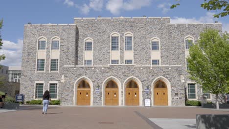 Several-students,-tourists-walk-past-famous-Cameron-Indoor-Stadium-on-Duke-University's-campus