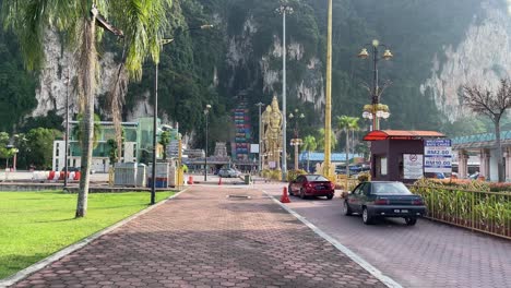 Los-Coches-Conducen-Hacia-La-Entrada-Principal-Del-Aparcamiento-Del-Famoso-Templo-Hindú-De-Las-Cuevas-De-Batu-En-Selangor,-Kuala-Lumpur,-Malasia