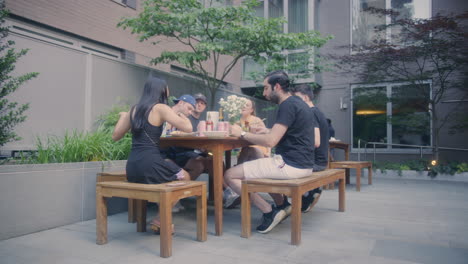 Grupo-De-Amigos-Milenarios-Disfrutando-De-La-Comida-En-El-Patio-Trasero-De-Nueva-York