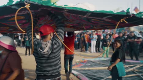 Grupo-De-Hombres-Que-Llevan-Una-Cometa-Gigante-Durante-El-Festival-De-Cometas-De-Sumpango-En-Sumpango,-Sacatepéquez,-Guatemala