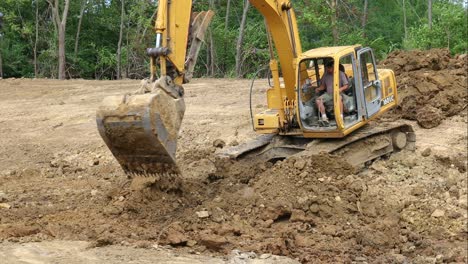 John-Deere-Hydraulikbagger-Gräbt-Schmutz-Vom-Teichboden-Und-Bewegt-Ihn-Zur-Oberseite-Der-Seitenwand-Des-Teichs-Und-Positioniert-Die-Maschine-Neu