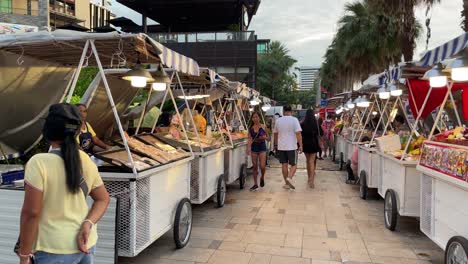 Los-Turistas-Caminan-Y-Compran-Comida-En-Un-Bazar-Nocturno-De-Comida-Callejera-Al-Aire-Libre-En-Pattaya,-Tailandia