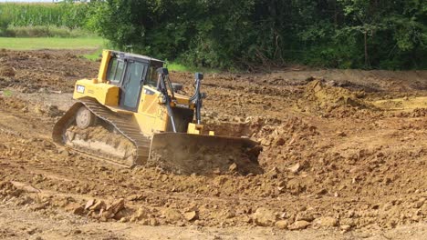 Caterpillar-D6t-Dozer-Schiebt-Schmutz-Das-Ufer-Hinunter,-Während-Er-Einen-Standort-Für-Einen-Neuen-Teich-Auf-Einem-Erschließungsgelände-Vorbereitet