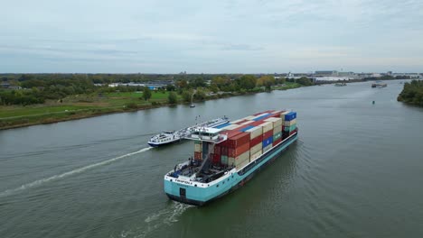 Aerial-Ascending-Shot-View-Off-Around-Stern-Of-Tripoli-Cargo-Ship-Navigating-Oude-Maas-Through-Puttershoek