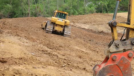 Großer-Und-Leistungsstarker-Raupen-Bulldozer,-Der-An-Einem-Hang-Arbeitet,-Um-Die-Seite-Eines-Teichs-An-Einem-Neuen-Landentwicklungsstandort-Zu-Bilden