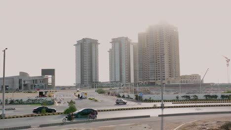 Torres-De-Peras-Y-Arrecifes-Vistas-A-Través-De-La-Niebla-De-La-Mañana-Con-El-Tráfico-Pasando-En-Karachi