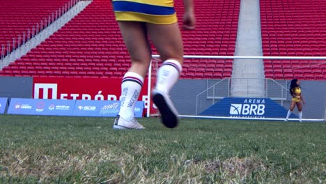 Low-angle-view-on-female-football-players-kicking-a-ball-towards-goalkeeper