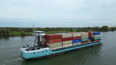 Aerial-Ascending-Shot-View-Off-Starboard-Side-Of-Tripoli-Cargo-Ship-Navigating-Oude-Maas-Through-Puttershoek