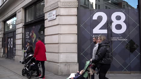 En-Cámara-Lenta,-Personas-Con-Cochecitos-Pasan-Por-Un-Espacio-De-Tienda-Vacío,-Conocido-Como-&quot;espacios-Muertos&quot;,-En-La-Calle-Argyll-Cerca-Del-Circo-De-Oxford