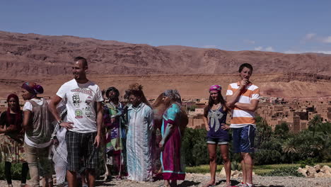 Tourists-take-pictures-with-local-villagers-and-camels-in-the-Moroccan-desert---time-lapse