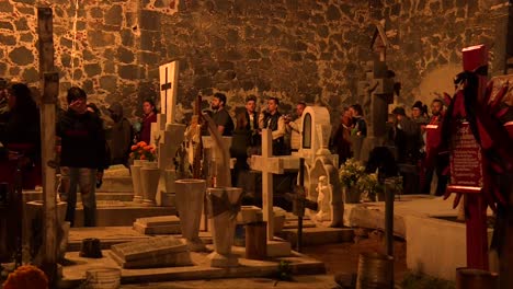 candle-on-fire-over-cempasuchitl-flowers-in-front-of-a-grave-in-a-traditional-cemetery-of-Mixquic-Mexico