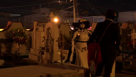 Catrin-Esqueleto-Hombre-Con-Una-Catrina-Caminando-En-Medio-De-Un-Famoso-Cementerio-En-Mixquic-Mexico