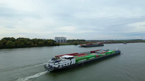 Vista-Aérea-Del-Buque-De-Carga-Virage-Que-Viaja-A-Lo-Largo-De-Oude-Maas-Con-Barcazas-Que-Transportan-Contenedores-De-Carga