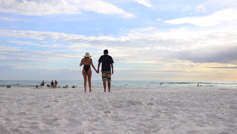 Pareja-Caminando-Hacia-El-Mar-En-La-Playa-De-Arena-De-Florida