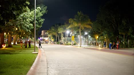 Panning-shot-of-a-neighborhood-in-Cancun-with-people-celebrating-halloween-asking-for-trick-or-treats-at-night