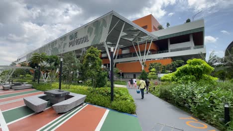 Trabajador-Que-Lleva-Una-Paleta-De-Agua-Camina-Hacia-El-Nuevo-Centro-Integrado,-Un-Punggol,-Singapur