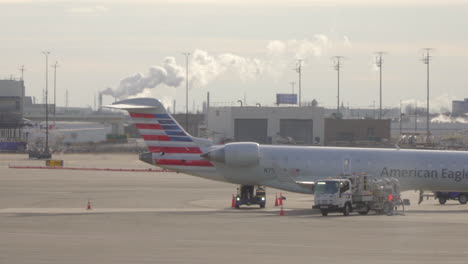 Flughafen-American-Airlines-Flugzeuge-Am-Flughafen-Mit-Schornsteinen-Im-Hintergrund-Geparkt