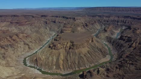 Tiro-De-Drone-Del-Cañón-Del-Río-Fish-En-Namibia---Drone-Está-Dando-Vueltas-Alrededor-De-Una-Colina-Circunscrita-Por-El-Río