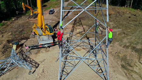 Grúa-Y-Tripulación-Erigiendo-Una-Torre-De-Transmisión-Eléctrica-Cerca-De-Jurmala,-Letonia---Vista-Aérea