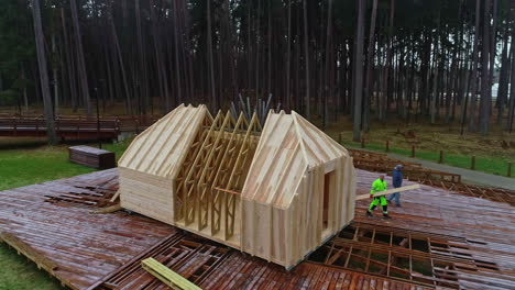 Imágenes-Aéreas-De-Una-Meseta-De-Madera-Y-Una-Casa-En-Construcción-Con-Un-Marco-Con-Armazones-En-Un-Bosque