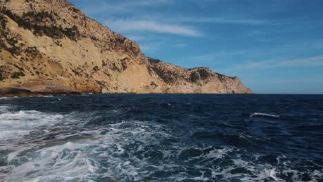 Woman-standing-on-the-edge-of-the-rocks-in-Ibiza